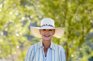 senior woman wearing wide-brimmed hat smiling